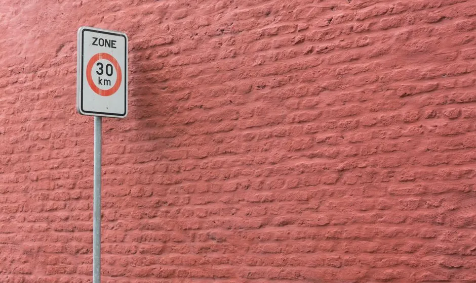 Panneau d'une zone à faibles émissions à l'entrée d'une ville, voitures circulant en arrière-plan